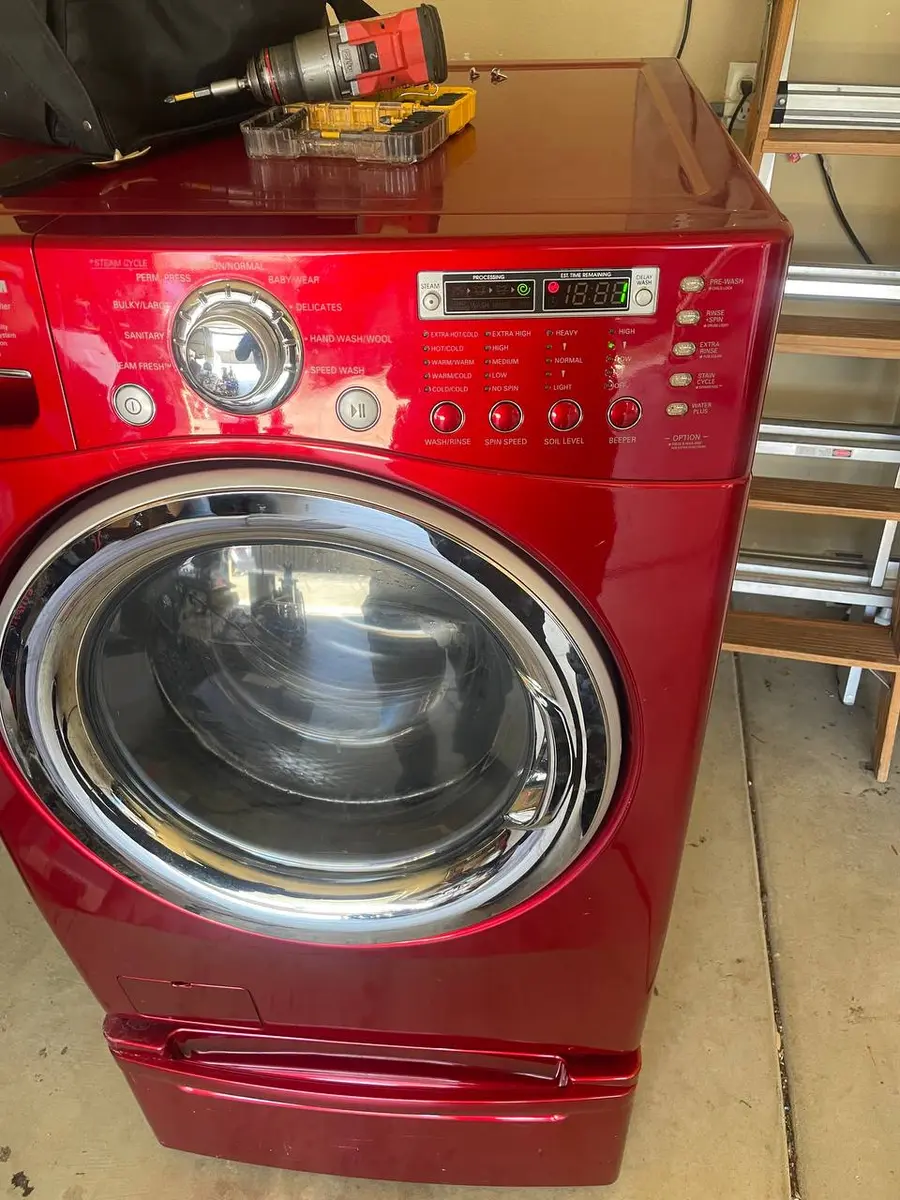 LG front-load washer with front panel removed during repair — EasyBear technician