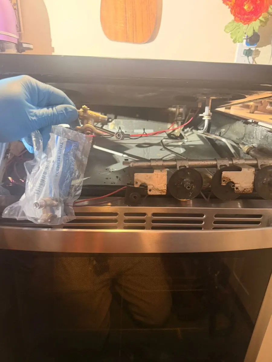 Gas range burner being repaired with protective gloves — EasyBear technician